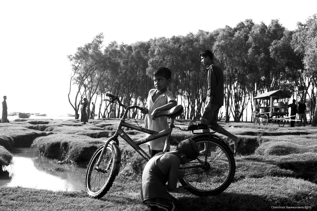Cycle King: These young boys are a focal point in a milieu of people, alone and in groups, that gather for an evening out within the changing terrain of Kattali, Chittagong’s mangrove beach.