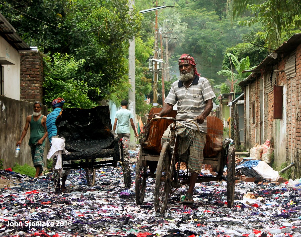 What Gets Leftover: A rickshaw driver passes over scrap material spilling onto the roadside from an apparel factory disposal point in Chittagong. With the apparel sector providing for the employment of millions and significant export revenue, Bangladesh’s complicated relationship with the industry is well-recorded.