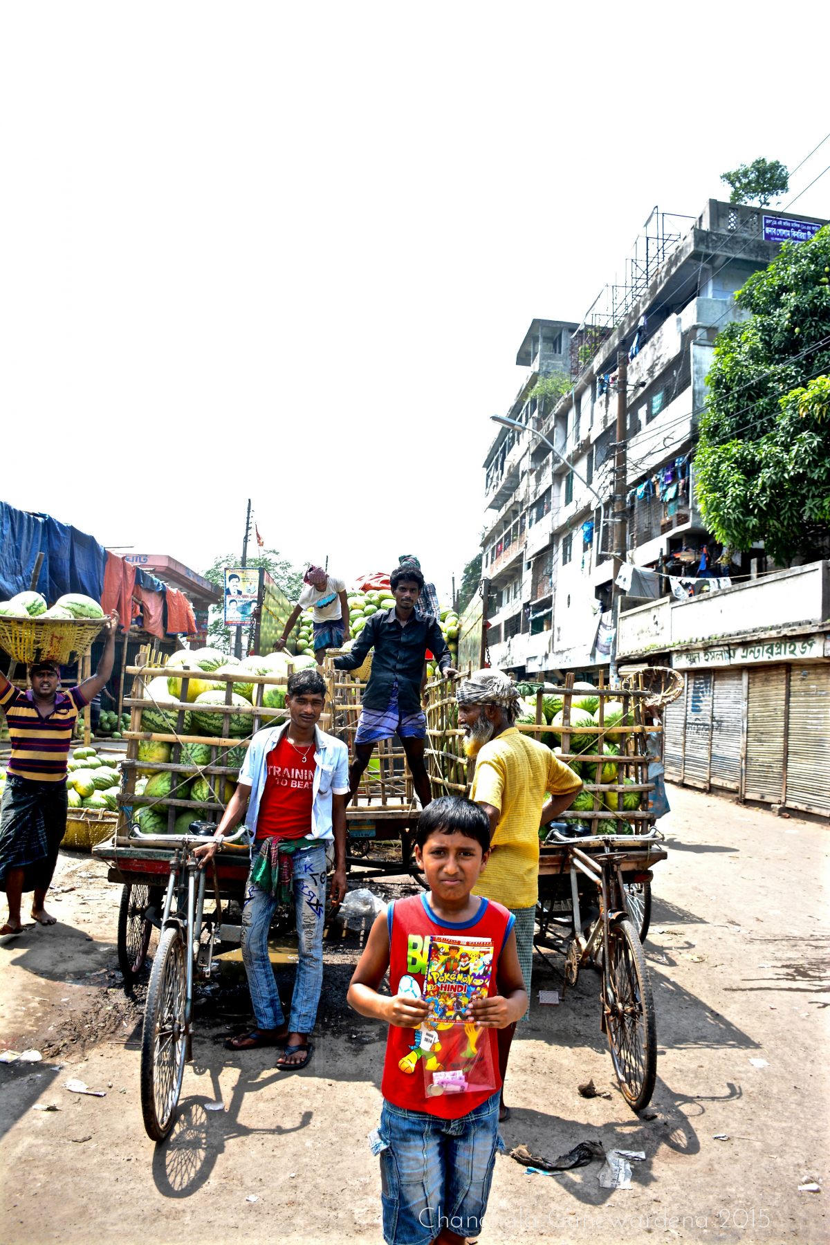 Of Melons And Men: fruits and veggies are unloaded at ports, alongside the more bountiful hauls of fish. Here, many large and heavy melons are being loaded on to cycle carts to be taken to market.