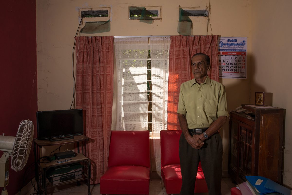 Hakeem stands in his living room, where he likes to listen to old Hindi songs on his stereo. Image credit: Roar.lk/Christian Hutter