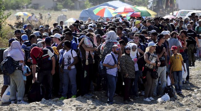 Migrants queue at a registration and transit point in Macedonia. Image courtesy: RT.com 